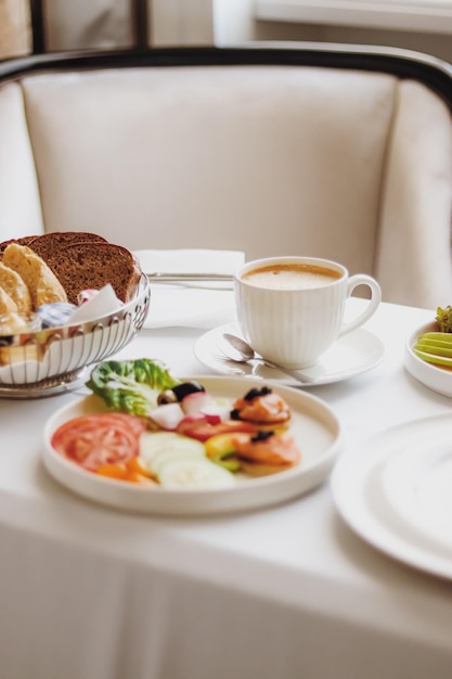 Luxushotel und Fünf-Sterne-Zimmerservice, verschiedene Speisenplatten, Brot und Kaffee als Frühstück auf dem Zimmer für Reisen und Gastfreundschaft