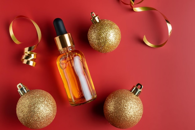 Luxuskosmetikprodukt antiage feuchtigkeitsspendendes und kollagenes gesichtsöl als geschenk schönheitskosmetik und hautpflege neujahrskonzept dekoration aus goldenen kugeln und konfetti