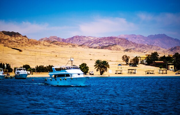 Luxusyacht, die vom idyllischen Sandstrand ins tiefblaue Meer geht