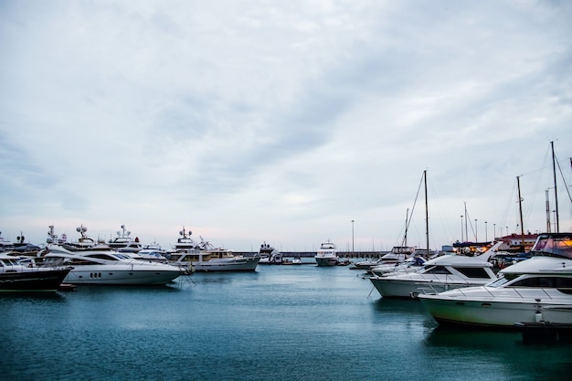 Luxusyachten, die bei Sonnenuntergang im Seehafen angedockt sind, Marineparkplätze moderner Motorboote und blaues Wasser, Ruhe, Entspannung und modischer Urlaub