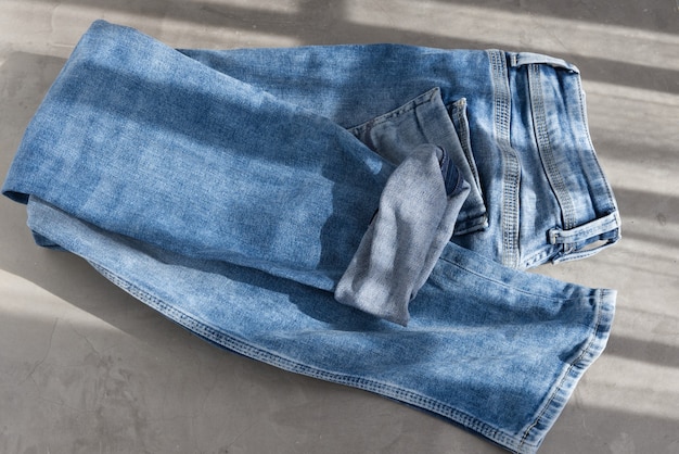 Una luz azul jeans doblados sobre un fondo gris luz del sol