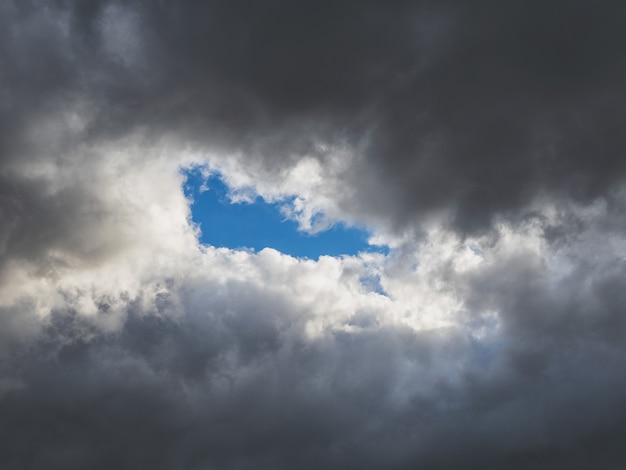 Foto luz azul nas nuvens escuras. céu nublado colorido ao pôr do sol. textura do céu, fundo abstrato da natureza, foco suave.