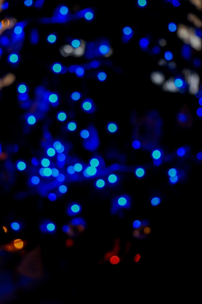 Luz de bokeh azul Defocused del árbol de Navidad en la noche de fondo azul bokeh