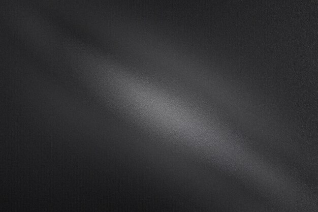 La luz brilla a través de la pared de metal de tierra negra en el fondo de textura abstracta de la habitación oscura