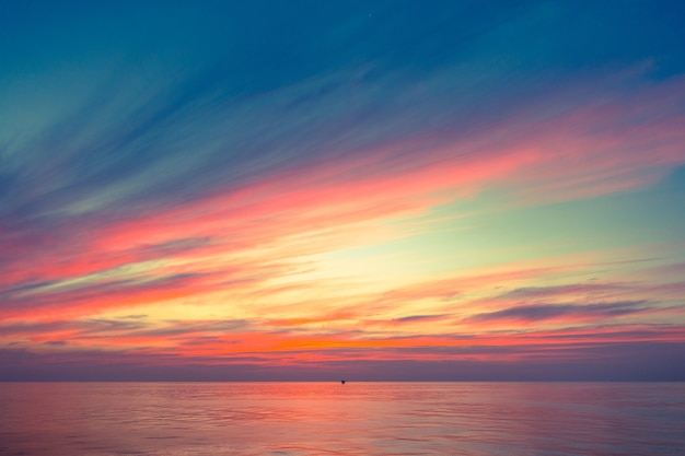 Foto luz cálida del cielo de la puesta del sol anaranjada ardiente con las nubes, hermosa para el fondo