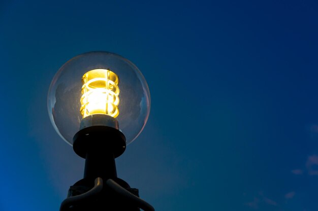 Luz de la calle de la linterna en el fondo de la tarde del crepúsculo