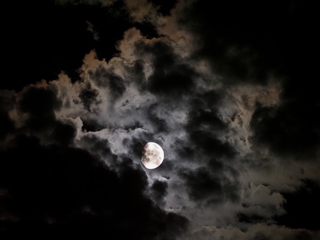 Foto luz da lua atrás das nuvens