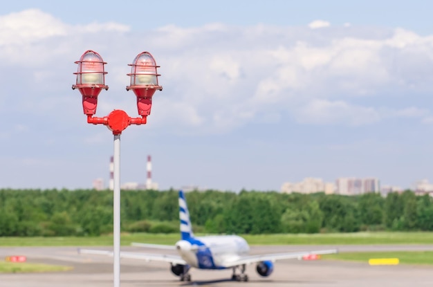 Luz de aviso de aviso vermelho com a luz acesa contra o céu azul feche a luz de aviso da aeronave em cima de um arranha-céu do aeroporto de construção para o conceito de segurança