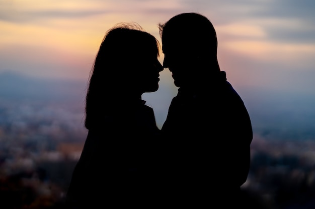 Luz de fundo de um casal apaixonado criando uma silhueta ao pôr do sol