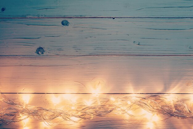 Luz de natal e decoração de natal em fundo de madeira branca com espaço de cópia.