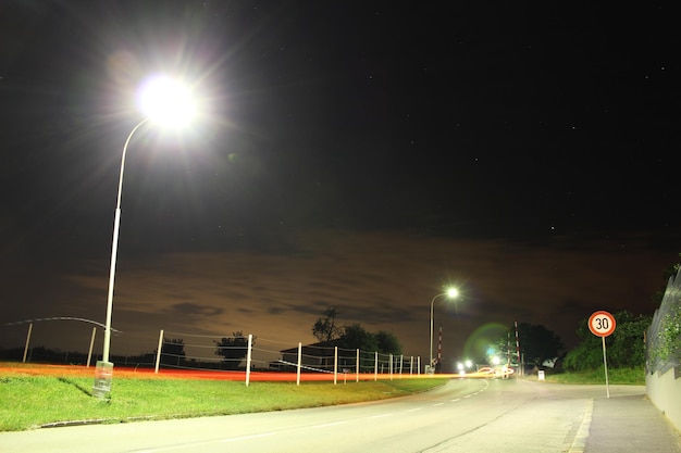 Luz de rua iluminada pela estrada contra o céu à noite