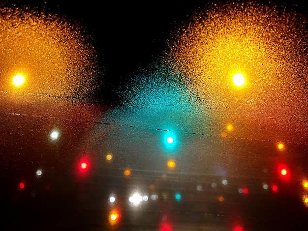 Foto luz de rua iluminada vista através de vidro à noite