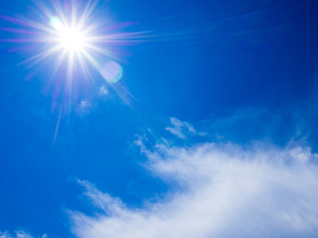 Luz de Sun com céu azul e as nuvens brancas com grão.