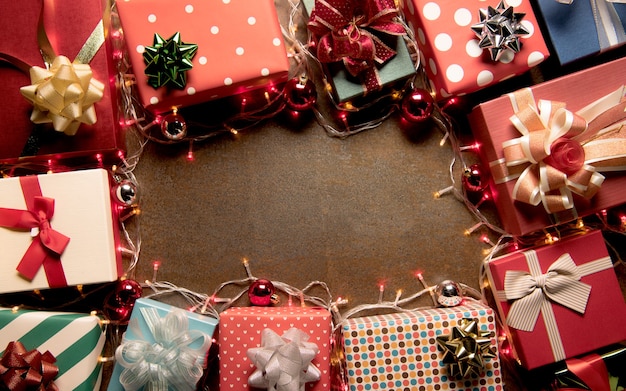 Luz de decoración navideña y cajas de regalo en la vista superior de fondo de madera con copyspace para marcos, regalos y decoración navideña festiva