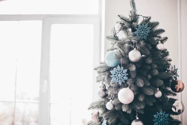 Luz do dia no quarto. Árvore de Natal com suporte de decoração no espaço em branco. Preparando-se para a celebração.