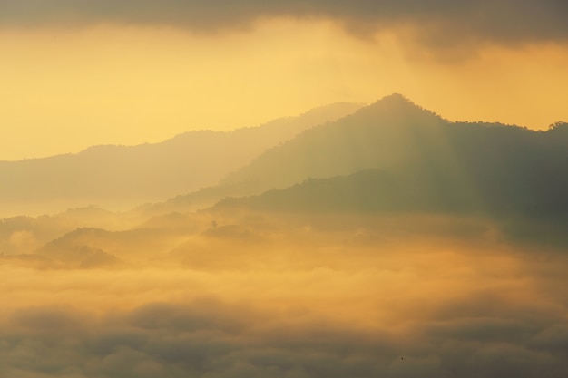 Luz do sol e nuvens na névoa da manhã em Phu Lang Ka, Phayao, Tailândia