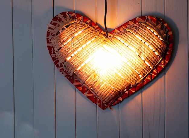 Una luz en forma de corazón cuelga de una pared de madera.