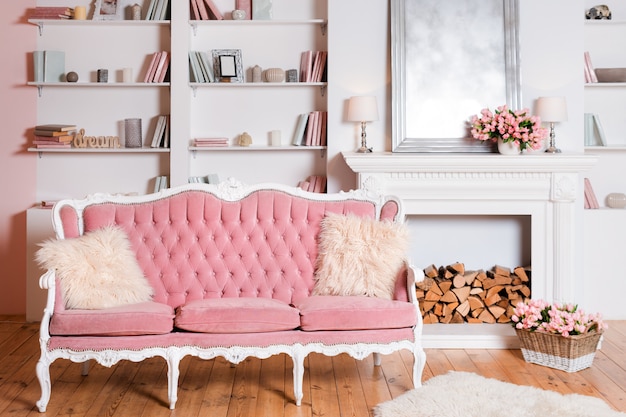 Luz interior moderno com lareira, flores da primavera e aconchegante sofá rosa
