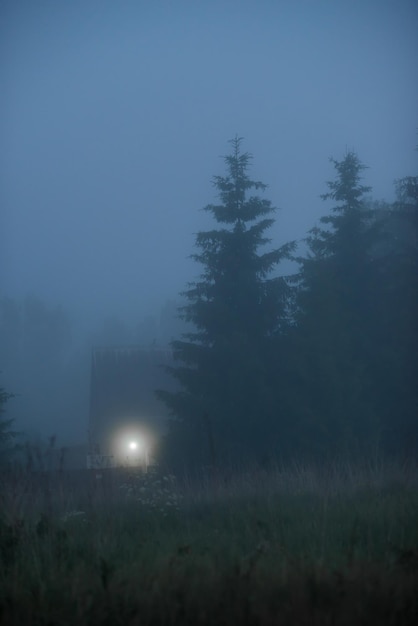 La luz de una linterna en la niebla al anochecer Tarde en el pueblo