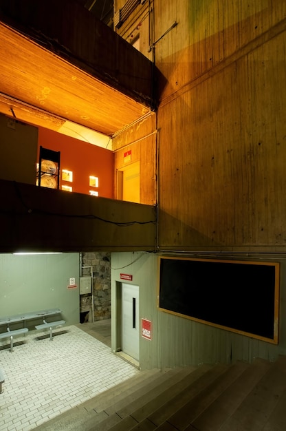 Luz naranja que contrasta con la arquitectura moderna de hormigón edificio de cemento escaleras brutalistas de una institución o escuela