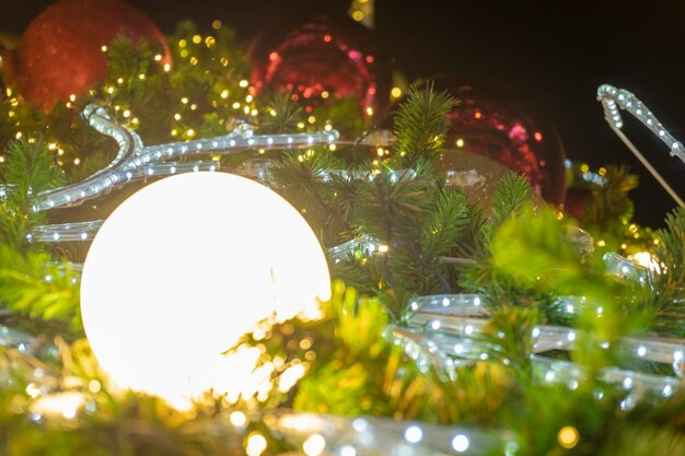 Foto luz de navidad iluminada en medio de decoraciones por la noche