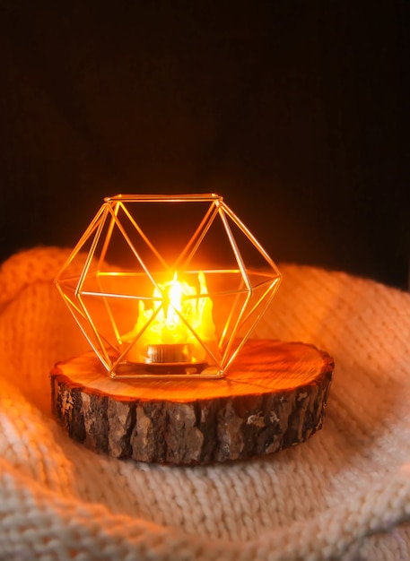 Luz quente feita à mão de vela de morte de cera natural de abelha em um castiçal em uma fatia de madeira.
