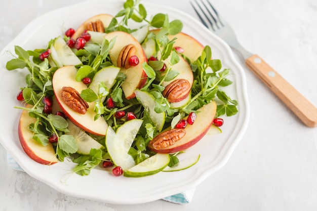 Luz - salada de romã de noz-pecã de maçã verde. Conceito de comida saudável vegan. Copie o espaço