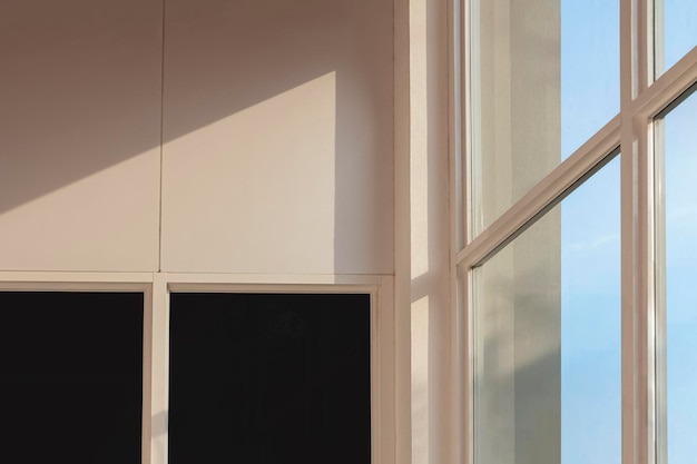 La luz del sol brilla a través de la pared de vidrio sobre vidrio tintado y cemento beige en todo el edificio de oficinas