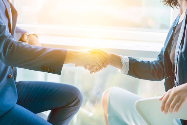 Foto la luz del sol cae sobre dos empresarios estrecharme la mano