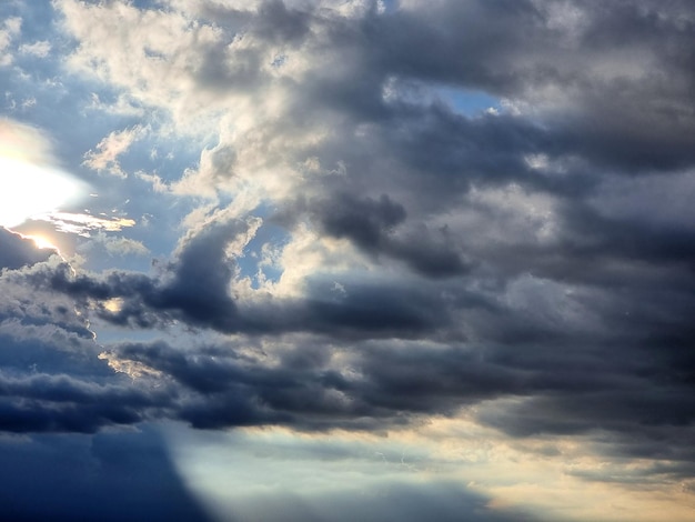 Foto luz del sol y nubes de nimbo en los fondos del cielo azul