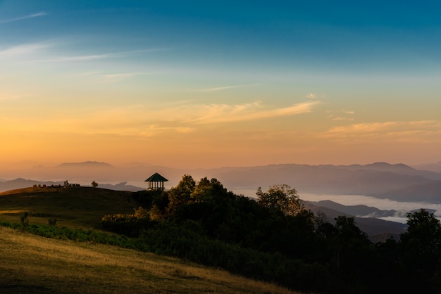 La luz del sol de la tarde brilla en la alta montaña y la densa niebla blanca.