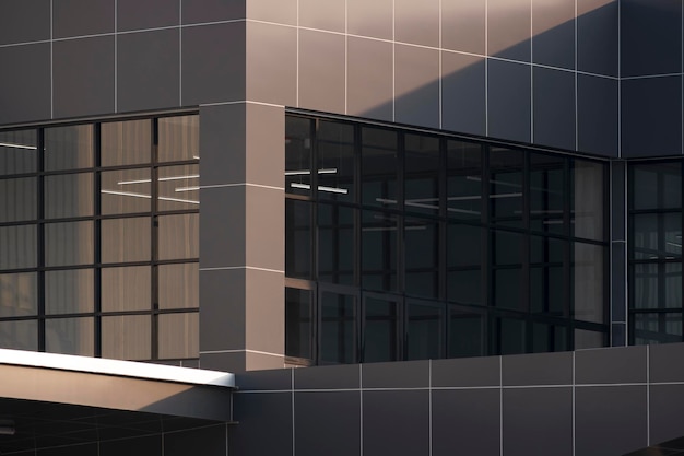 Luz solar e sombra na parede de vidro e superfície de ladrilho composto de alumínio marrom do edifício moderno