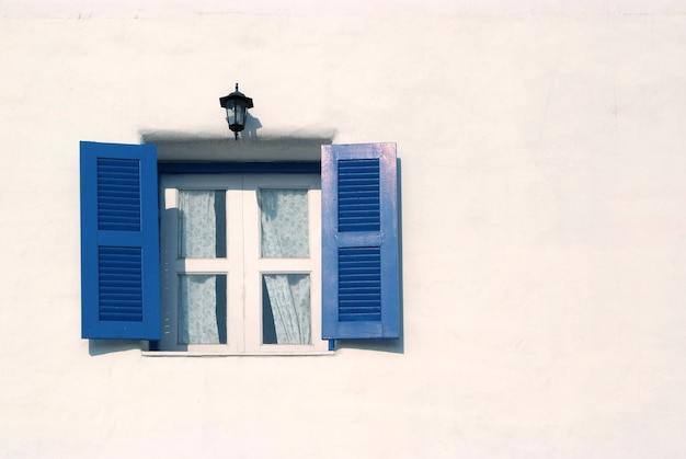 Luz y sombra en la ventana azul y la pared blanca