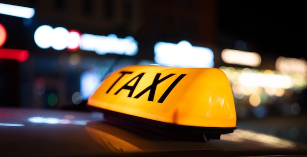 Luz de taxi en la calle oscura en el cartel de la cabina nocturna en el techo del vehículo que brilla en la oscuridad