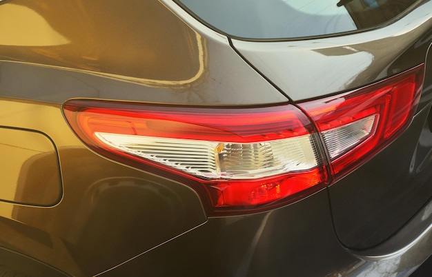 Luz trasera roja de un coche de pasajeros marrón de primer plano foto detallada de una de las partes del coche