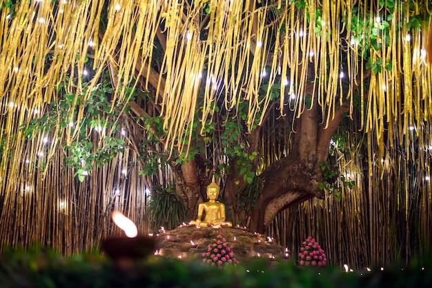 Luz de velas con estatua de Buda en Wat Pan Tao