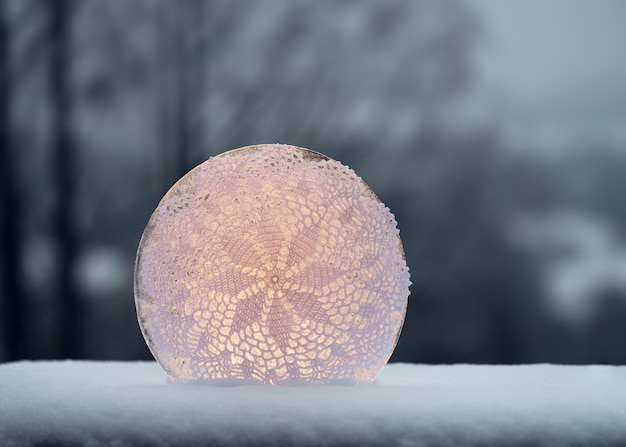 Luz de velas hechas a mano de escultura de hielo con servilleta de punto blanco y una vela detrás