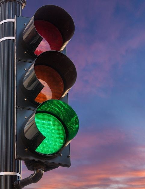 Foto luz verde no sinal de trânsito contra o nascer do sol como conceito de esperança