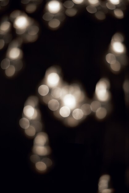 Luzes de bokeh branco na guirlanda de Natal escura