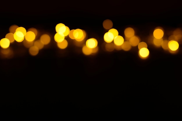 Luzes de brilho dourado sobre fundo preto sem foco Espaço de cópia de fundo de aniversário festivo