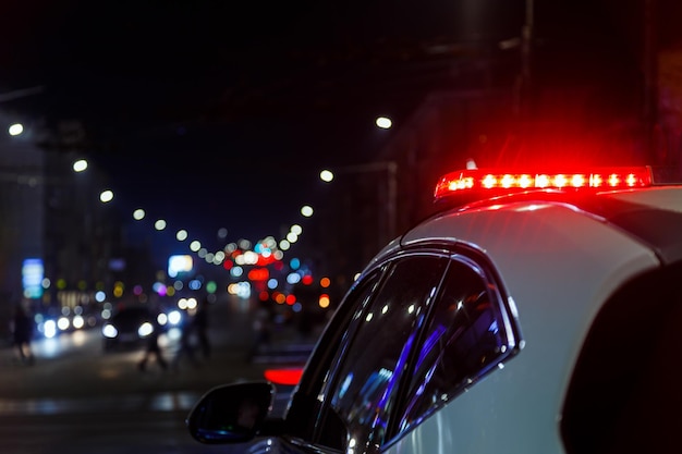 Foto luzes de carro de polícia na cidade noturna com foco seletivo e bokeh