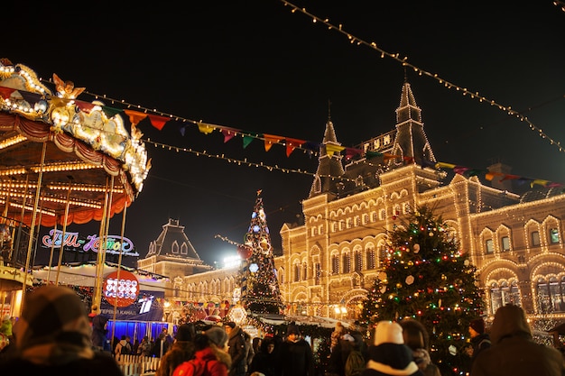 Luzes de celebração e decorações na Praça Vermelha para o Natal festivo e ano novo. Brilhando luzes amarelas na fachada GOMA em Moscou, Rússia. Paisagem urbana de noite de Moscou