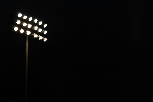 Luzes de inundação do estádio em um campo esportivo à noite com espaço para cópia