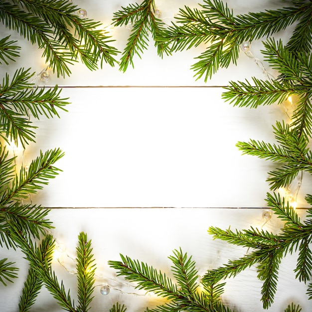 Luzes de Natal guirlanda borda circular e ramos de abeto com espaço de cópia.