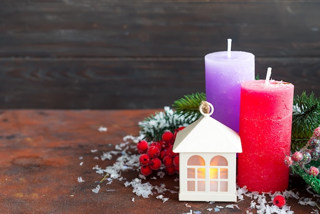 Luzes de natal, lanternas de forma pequena casa com velas e abeto na pedra.