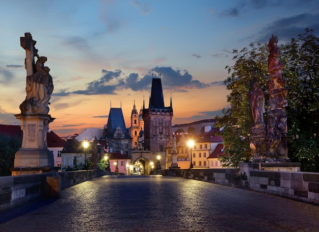 Luzes de rua iluminadas na Ponte Carlos em Praga ao nascer do sol