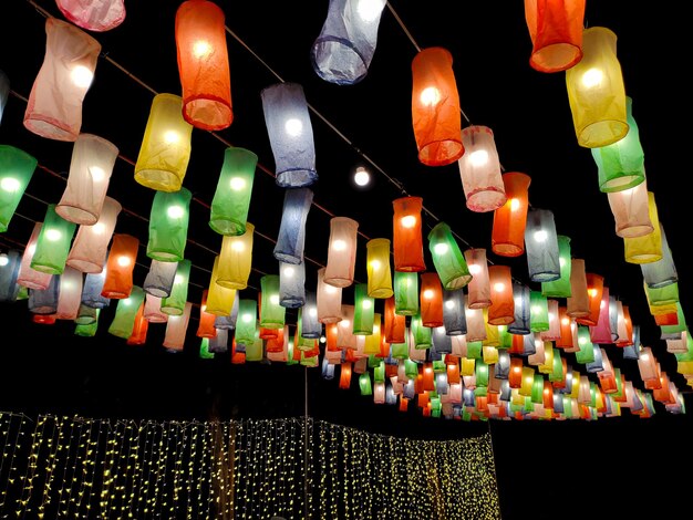 Luzes decorativas e lanternas coloridas são feitas de papel colorido à noite para festivais ou locais