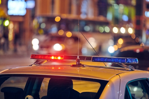 Luzes do carro de polícia na rua da cidade à noite. Luzes vermelhas e azuis.