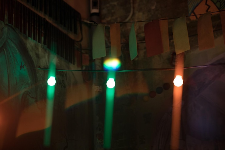 Foto luzes iluminadas na rua por um edifício à noite