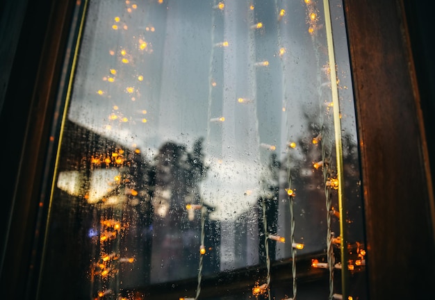 Luzes rústicas na janela com chuva Nostalgia à noite Linda foto de mau tempo